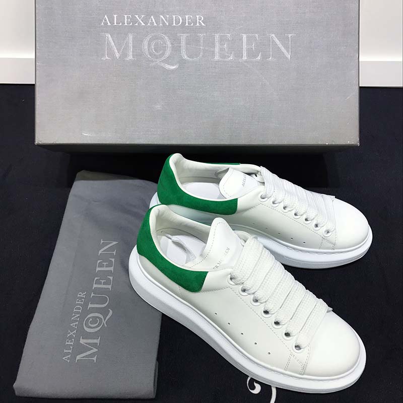 Close-up detail of the oversized tongue and green accent on Alexander McQueen sneakers