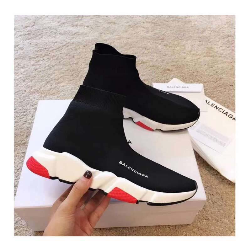 Close-up of white and red Balenciaga logo on black knit Speed Trainers