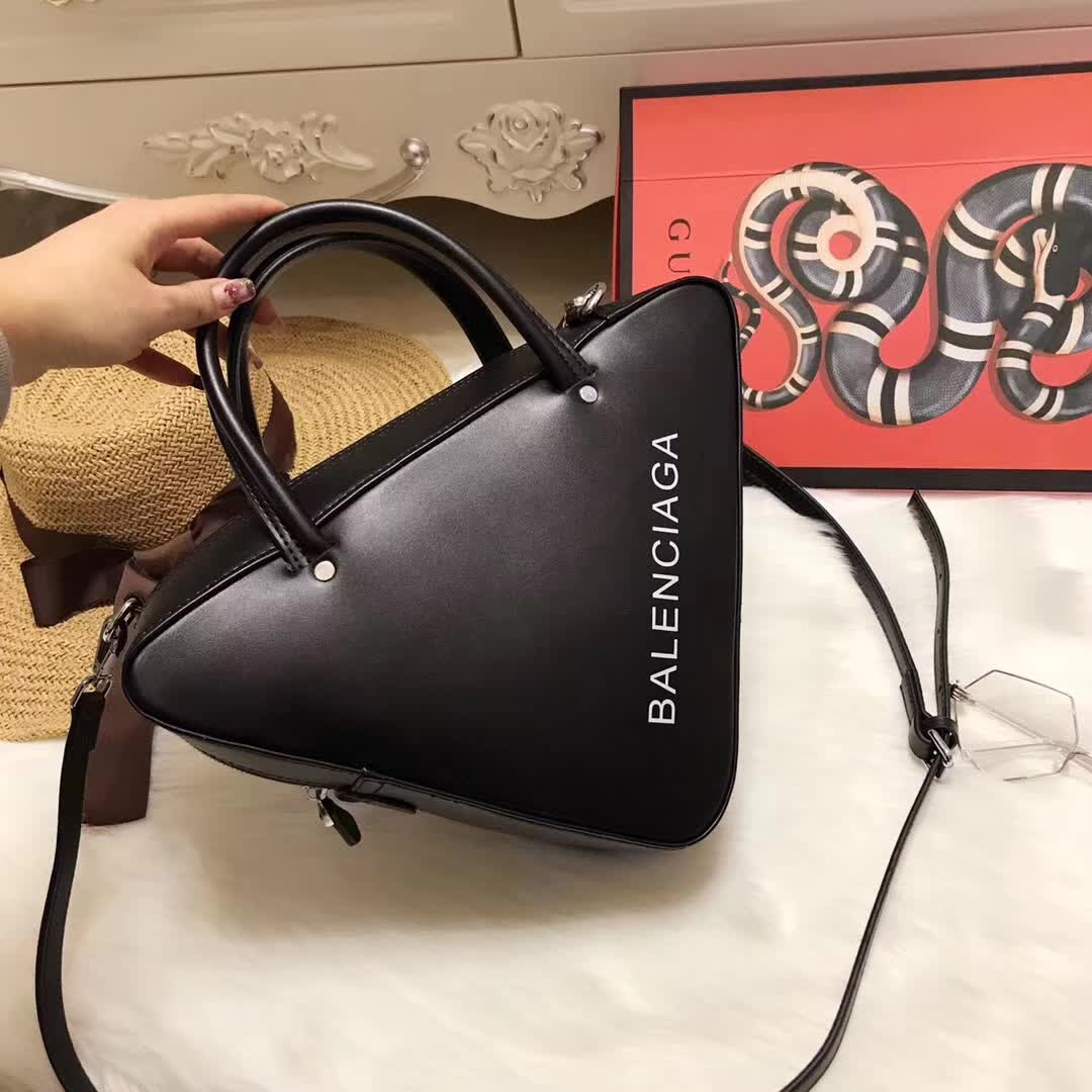 Side angle showing compact triangle silhouette of Balenciaga Triangle Duffle Small bag