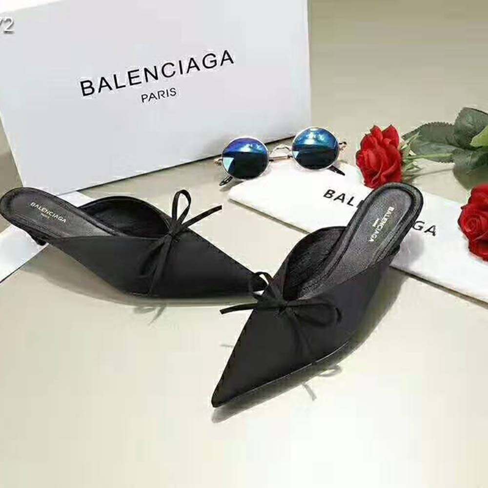 Close-up on black satin upper and pointed toe detail