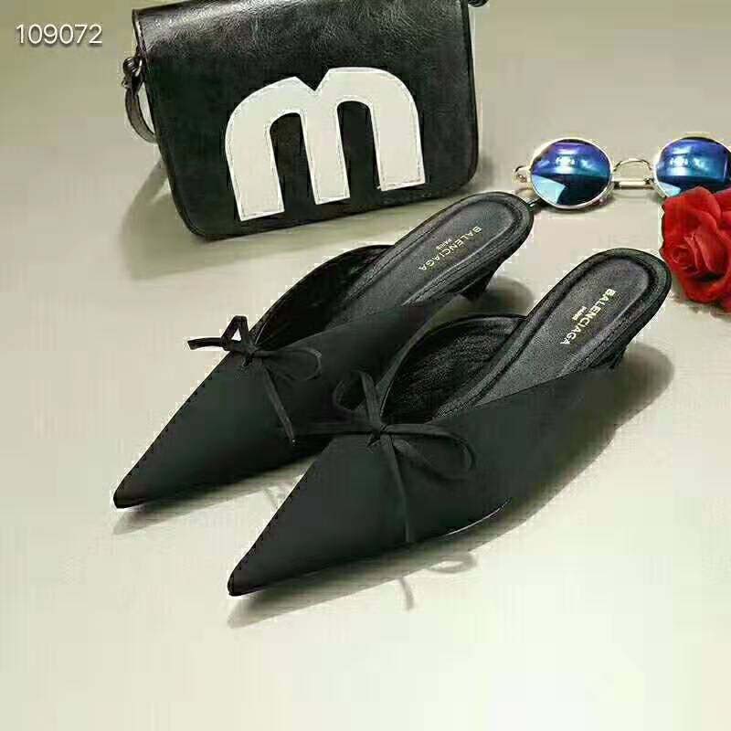 Detail shot of sculpted knife heel on Balenciaga satin mules