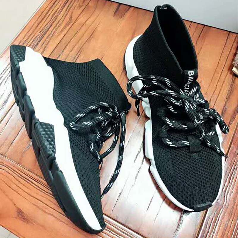 Close-up on black knit fabric and embossed logo on Speed Trainers