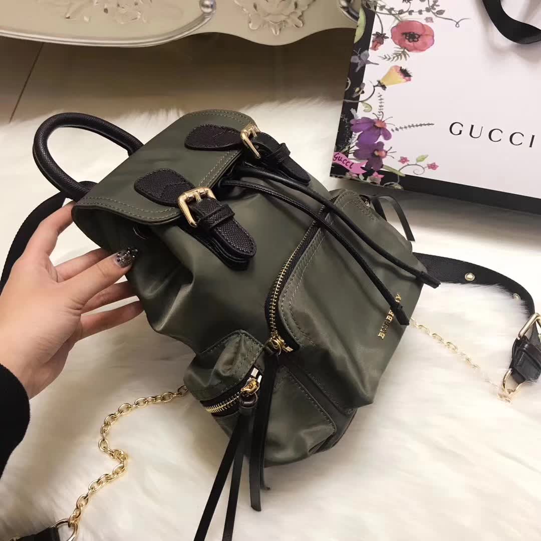 Side angle showing adjustable straps on Burberry Medium Rucksack in dark green