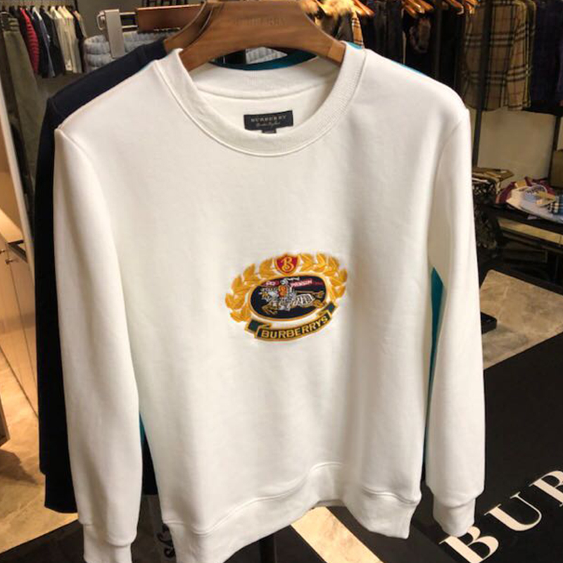 Close-up detail of embroidered Burberry logo on white sweatshirt