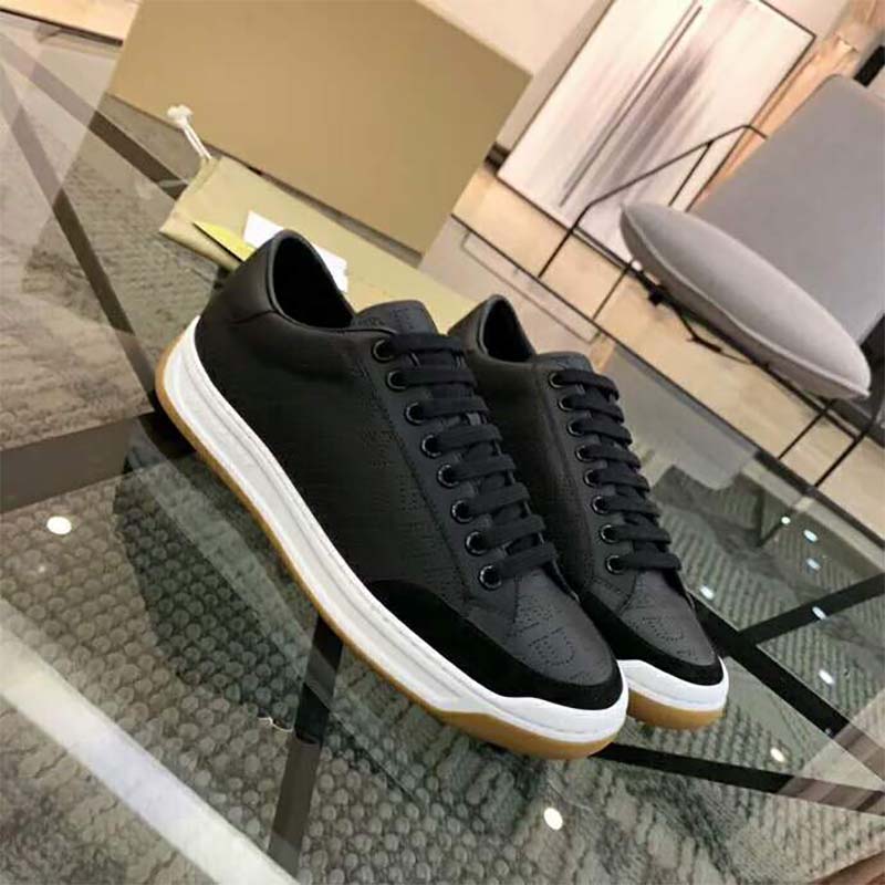 Close-up of Burberry logo print detail on black leather sneakers