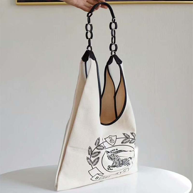 Side angle showing leather handles and canvas texture of Burberry shopper