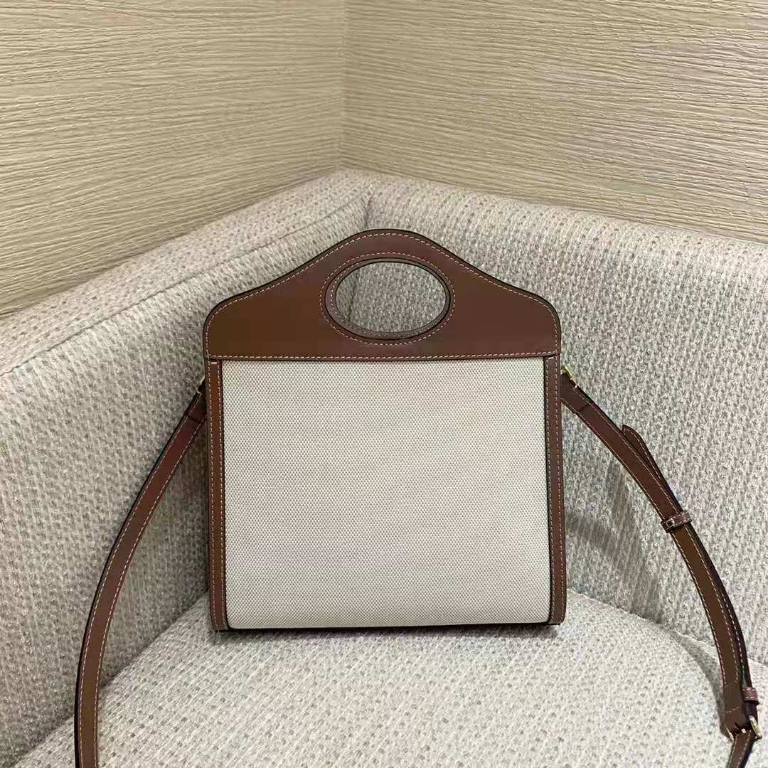 Side angle showing texture and strap of Burberry Women Mini Two-Tone Canvas and Leather Pocket-Beige