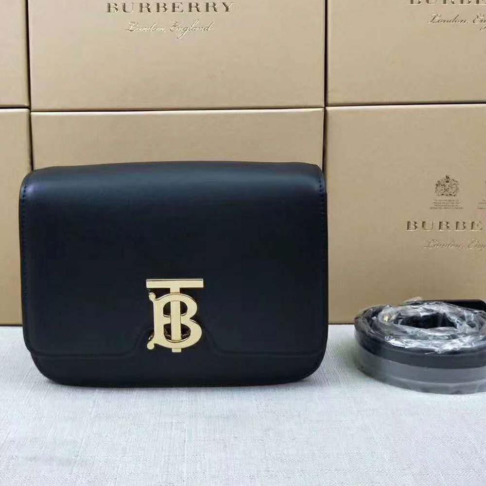 Side angle highlighting smooth black leather and gold-tone hardware detail