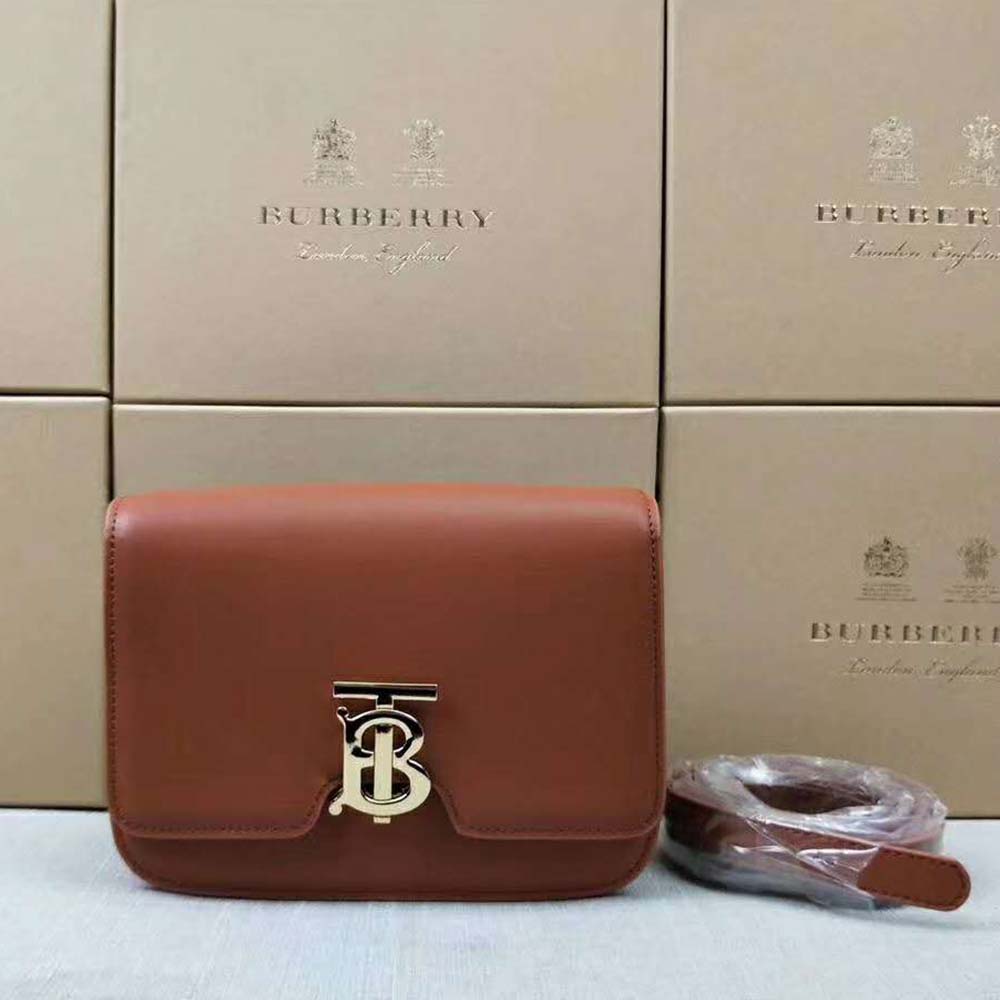 Close-up detail of gold TB hardware on Burberry Women Small Leather TB Bag-Brown