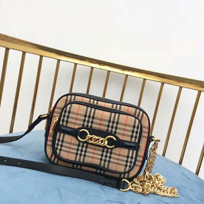 Close-up of Burberry check fabric and silver chain on camera bag