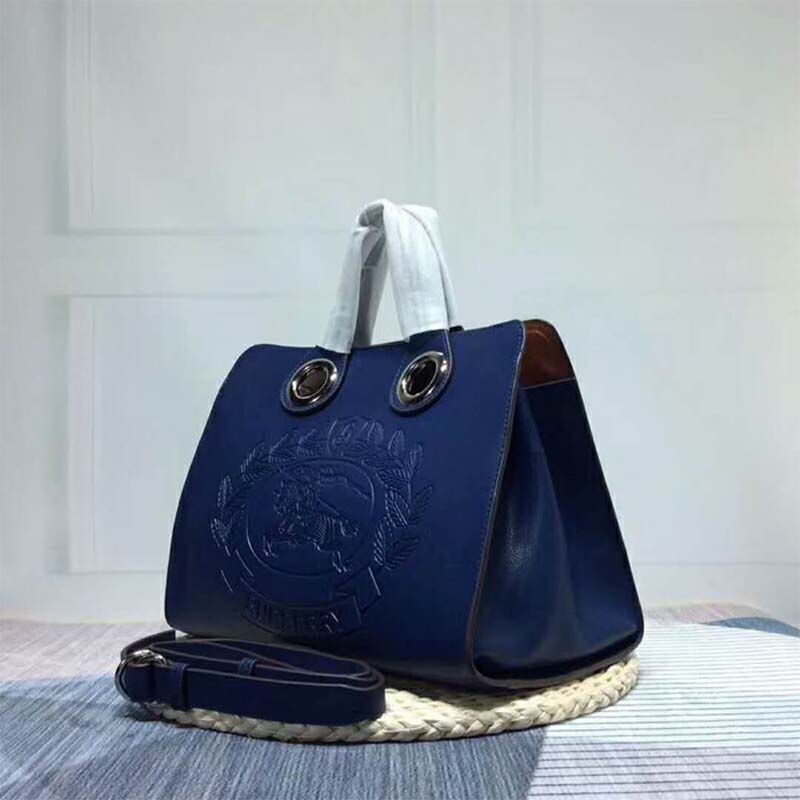 Side angle showing spacious interior of Burberry Women The Leather Crest Grommet Detail Tote-Blue