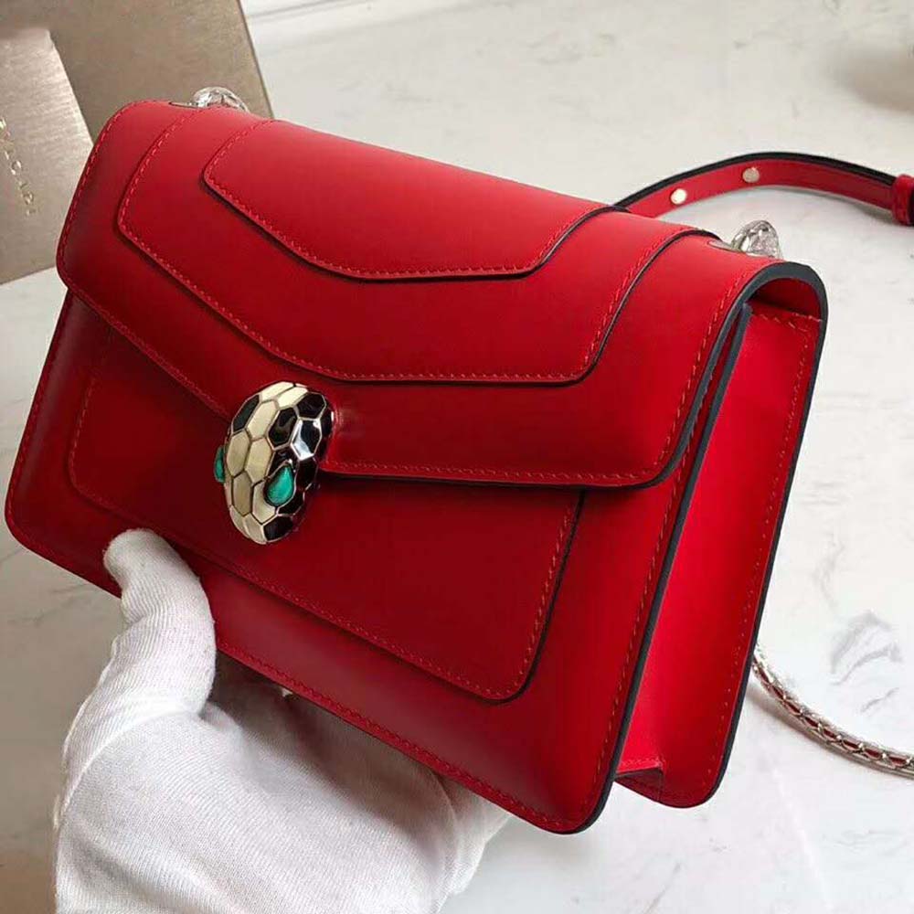 Side angle showing compact silhouette of Bvlgari Women Flap Cover Bag in red