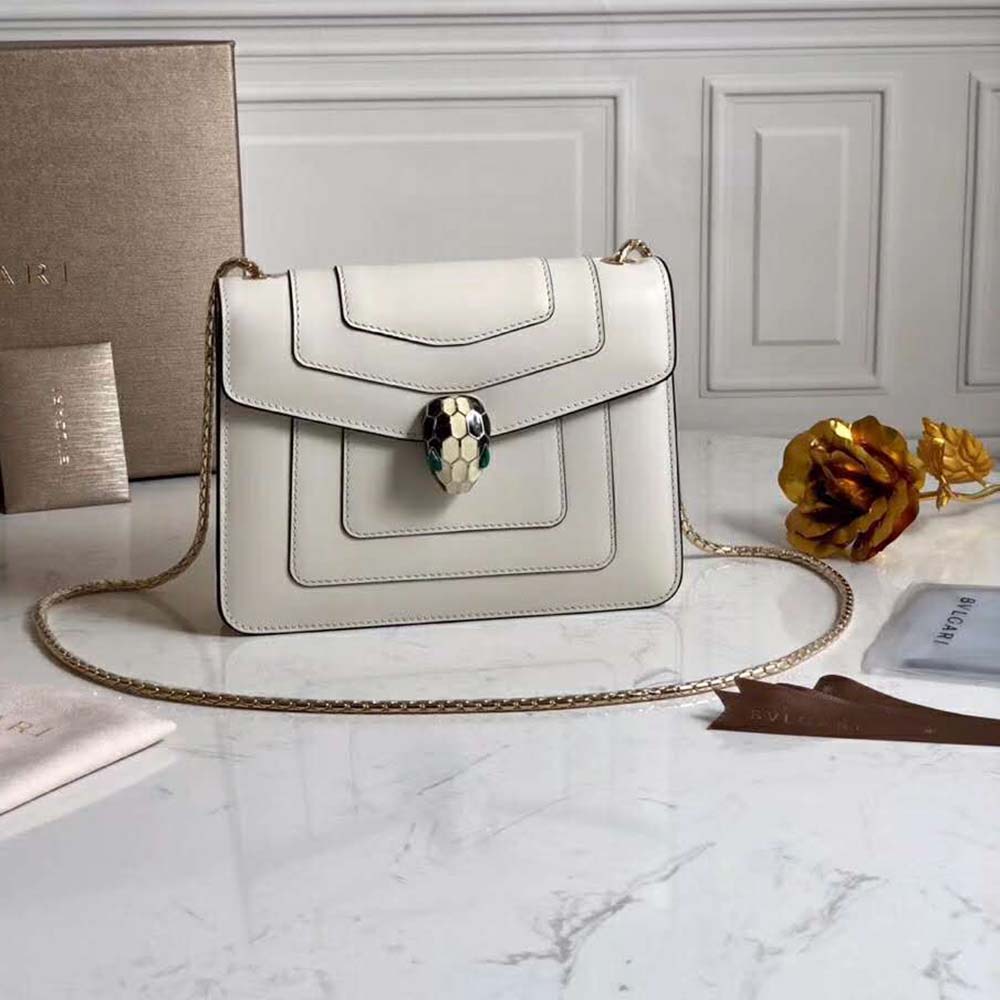 Close-up of gold Serpenti snakehead clasp on Bvlgari white bag