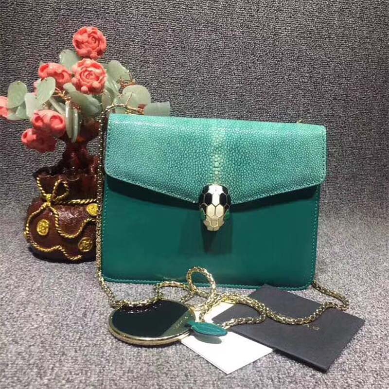 Close-up of Serpenti serpent head clasp on the green calfskin bag