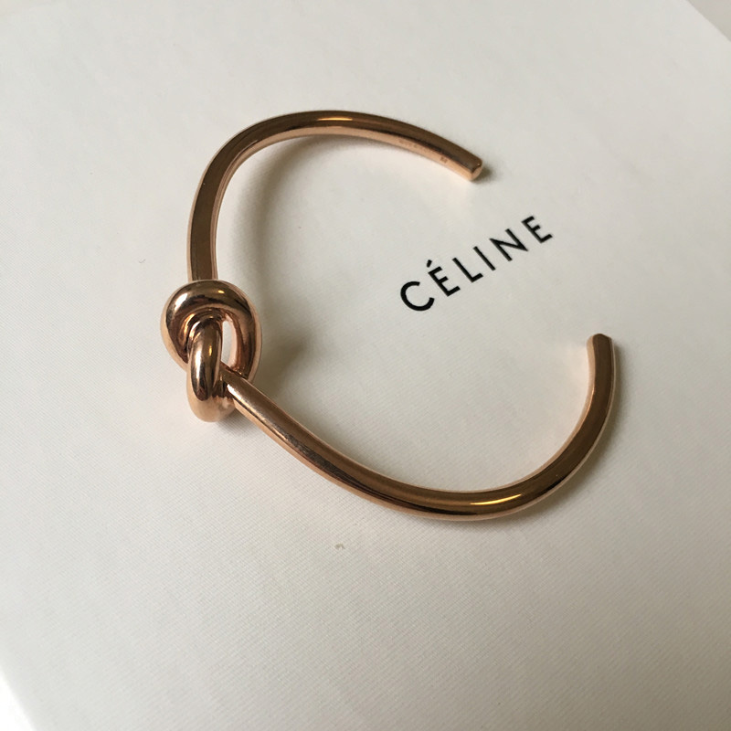 Wrist shot of Celine Women Knot Extra-Thin Bracelet paired with elegant outfit
