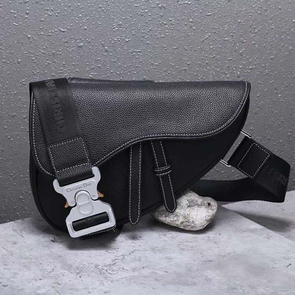 Close-up of polished metal ‘D’ hardware on Dior Men Saddle Bag