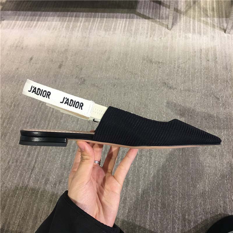 Close-up of black satin J’Adior ribbon on Dior ballerina shoes