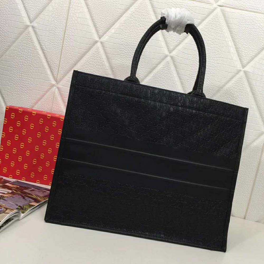 Close-up of Dior Oblique jacquard pattern on black tote bag