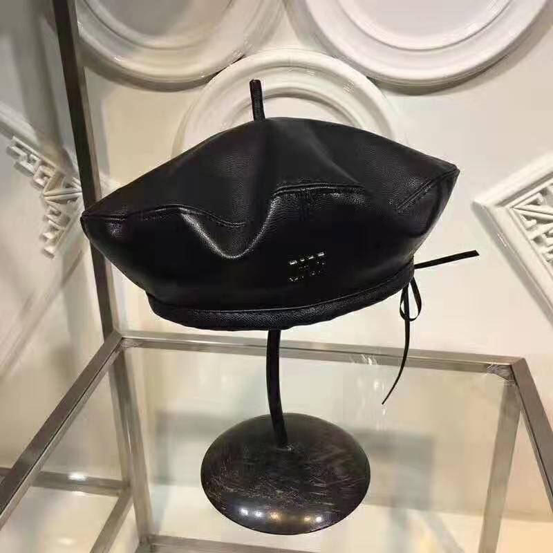 Close-up of embossed Dior logo on black leather beret