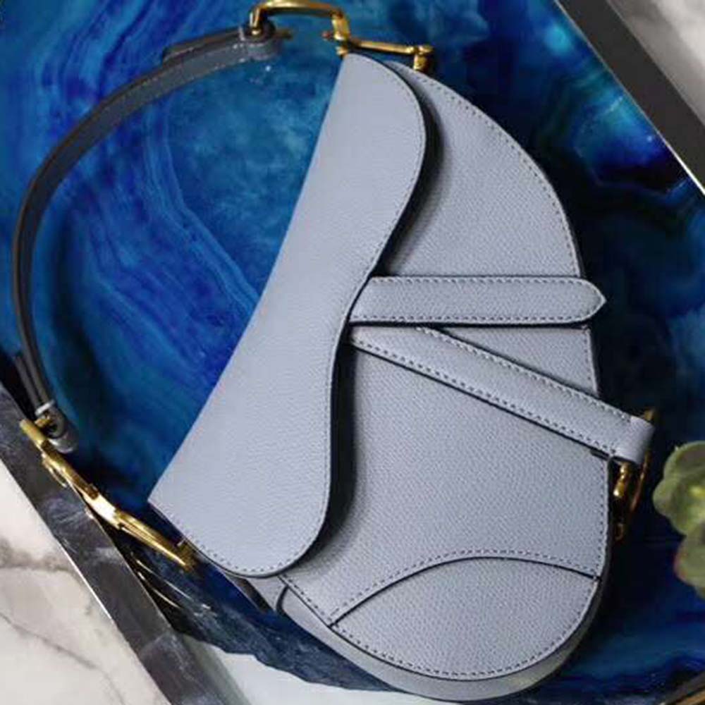 Side angle showing silhouette and strap detail of Dior Women Mini Saddle Bag in blue
