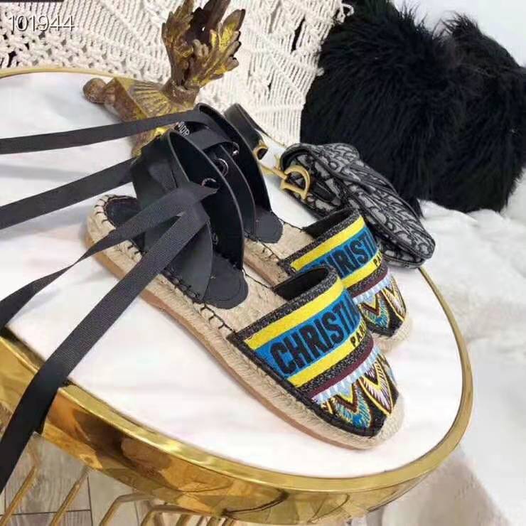 Close-up detail of aqua canvas and Dior embossed hardware on espadrille