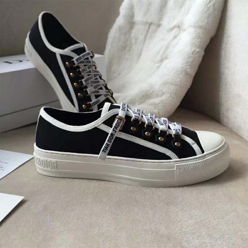Close-up of Dior logo detail on black canvas low-top trainer