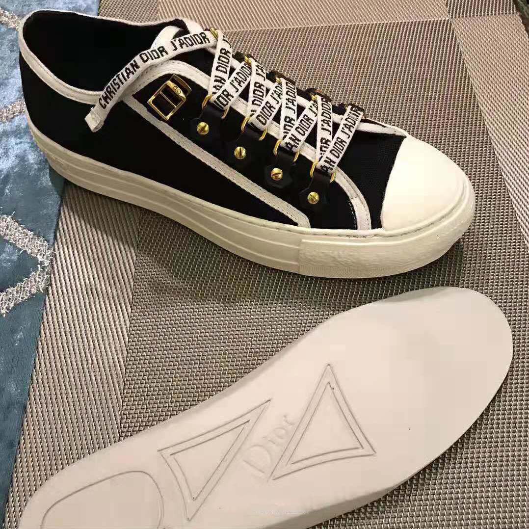 Close-up of Dior logo detail on black canvas sneaker side