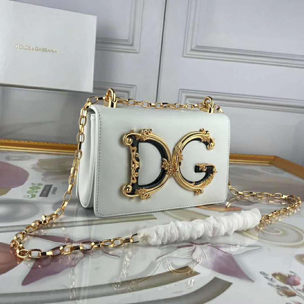 Close-up of gold-tone D&G logo hardware on white shoulder bag