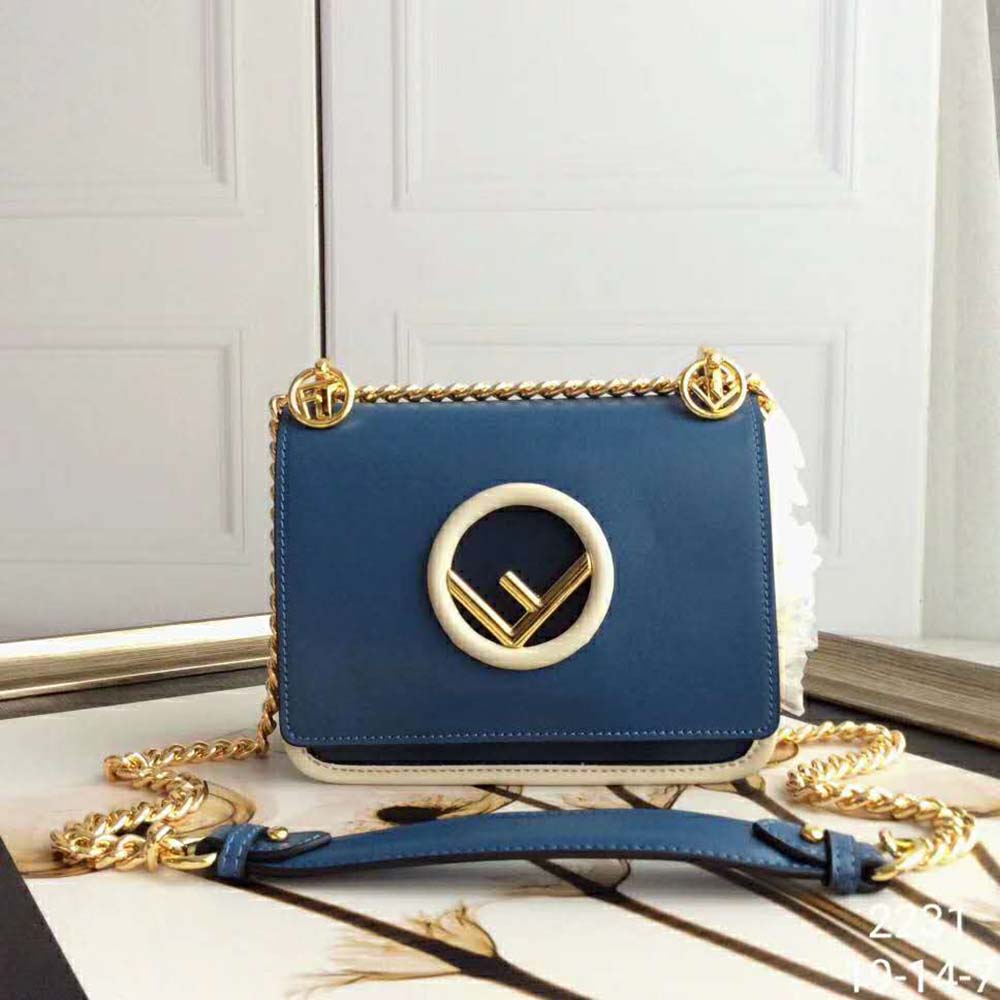 Close-up of gold Fendi logo hardware on navy leather mini-bag