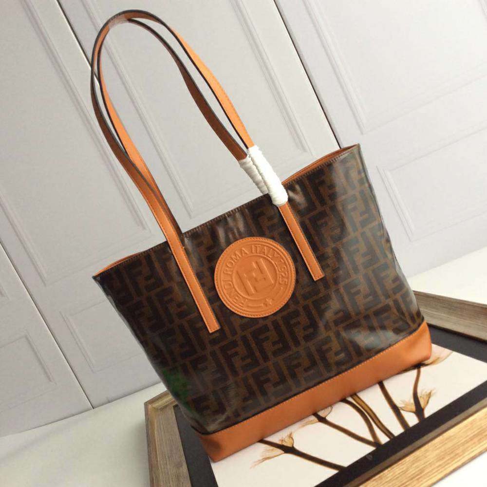 Close-up on gold-tone hardware and brown leather texture of Fendi shopper