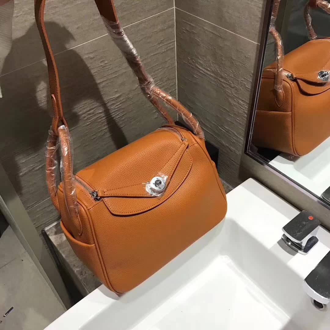 Close-up on polished silver hardware and brown leather texture of Hermes Lindy 30