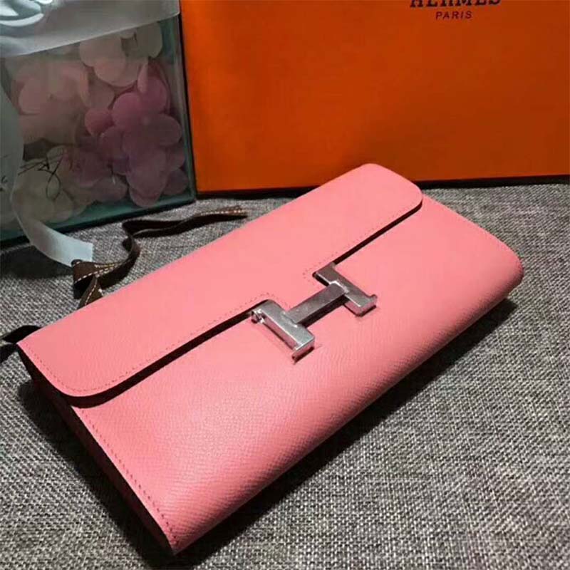 Close-up of gold H clasp and pink leather detail on Hermes Women Constance Wallet