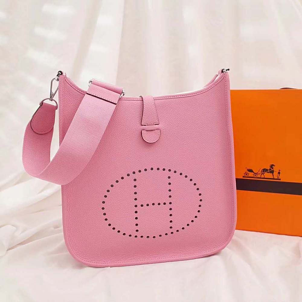 Close-up detail of pink leather texture and adjustable strap on Hermes bag