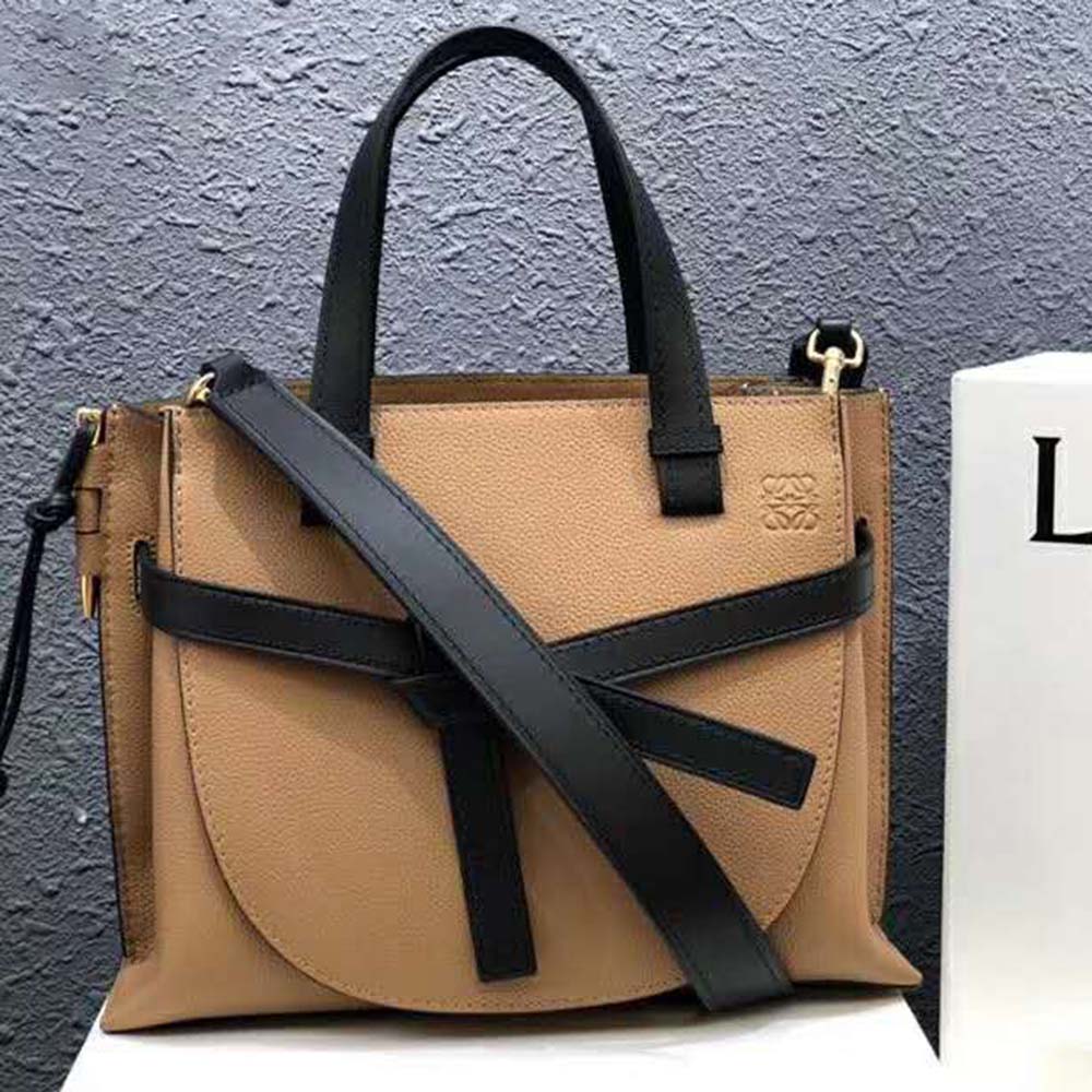 Close-up detail of Loewe gate clasp and knotted leather strap on brown bag