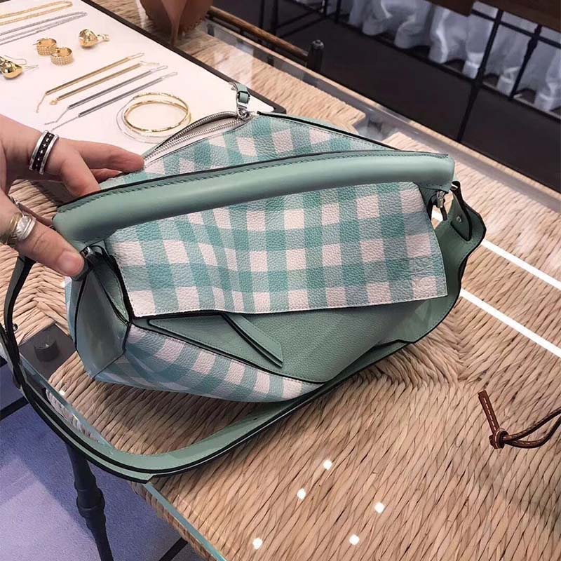 Side profile showing structured silhouette of Loewe Women Puzzle Gingham Bag