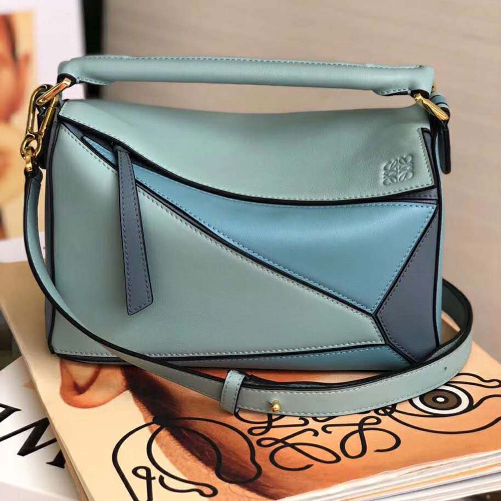 Side angle showing adjustable strap of Loewe Women Puzzle Small Bag in blue leather