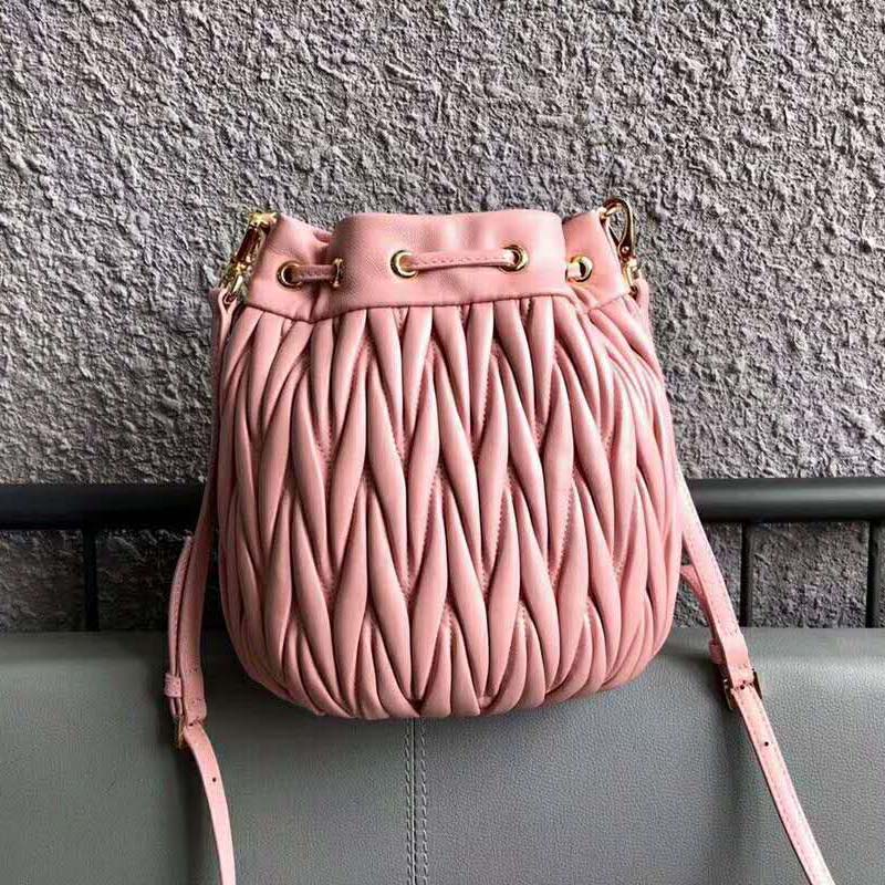Side angle highlighting silhouette and pink leather texture of Miu Miu Women Matelasse Leather Bag-Pink