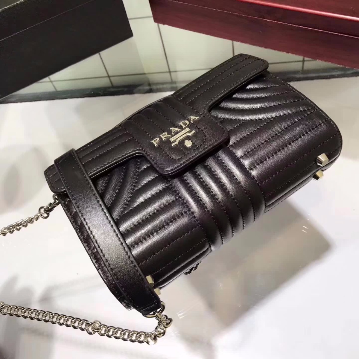 Close-up of gold-tone logo plaque on Prada Diagramme Big Leather Handbag