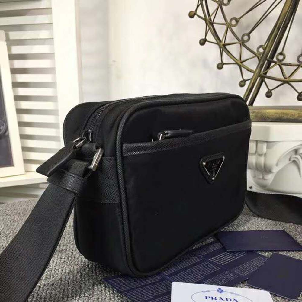 Close-up of zipper and brushed metal Prada plaque on nylon bag
