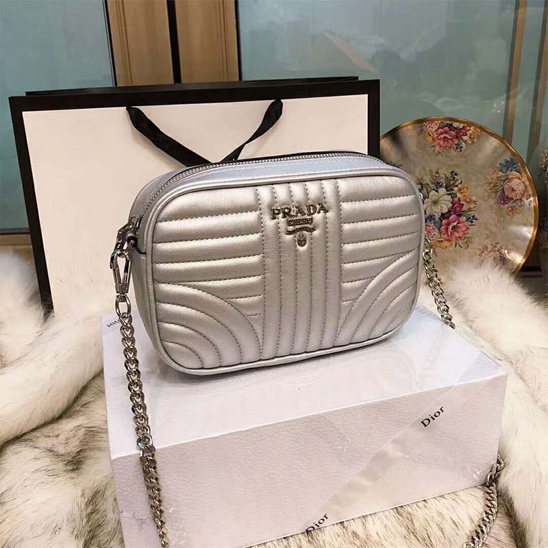 Close-up detail of silver hardware and Prada logo on the shoulder bag