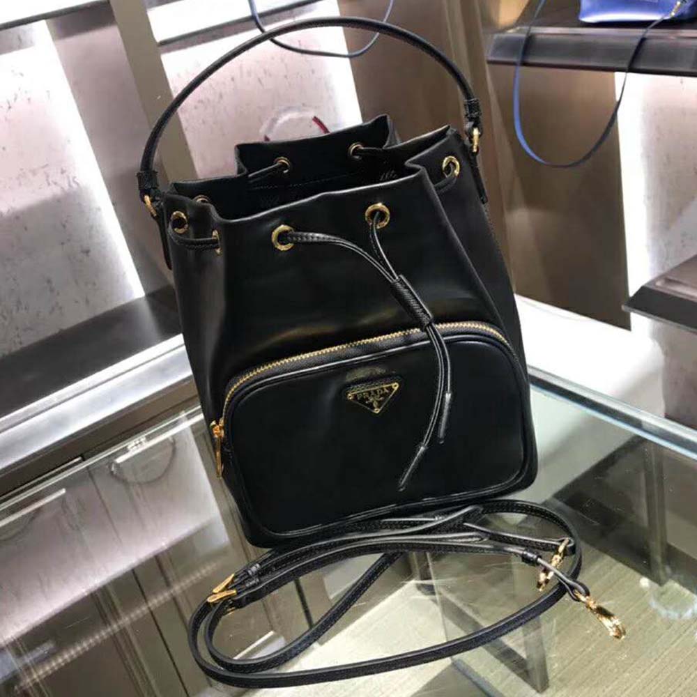 Close-up of gold-tone hardware and Prada logo on leather bucket bag