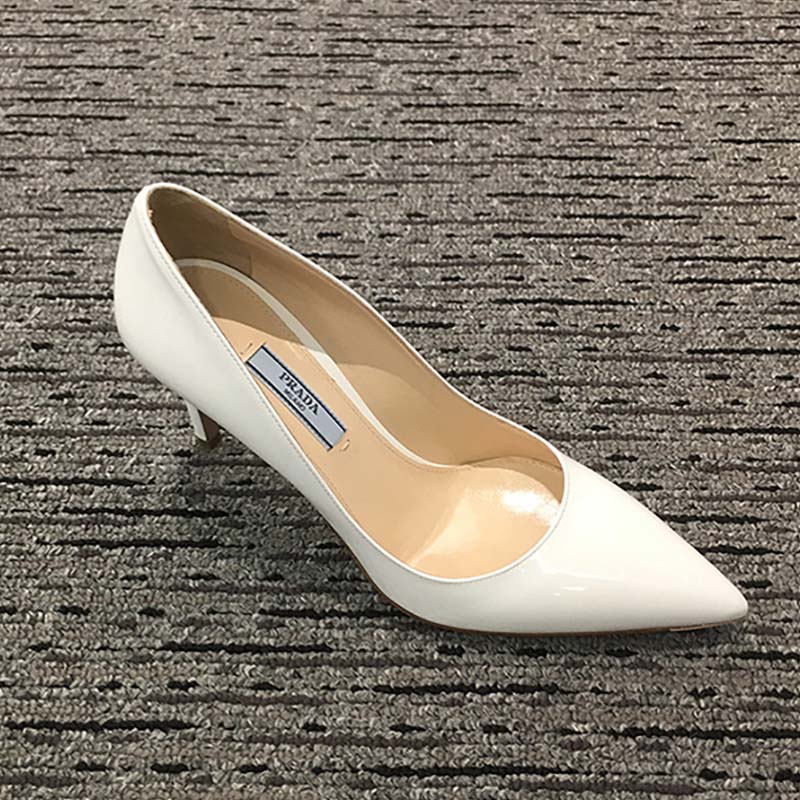 Close-up on glossy patent leather and pointed toe of Prada pumps