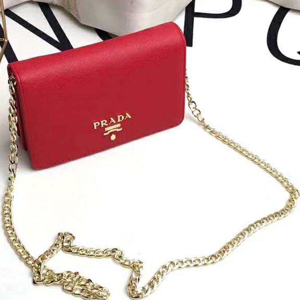 Close-up of Prada logo and gold-tone hardware on red shoulder bag