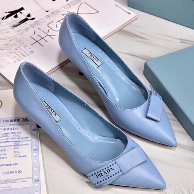 Close-up of blue leather and bow detail on Prada pumps
