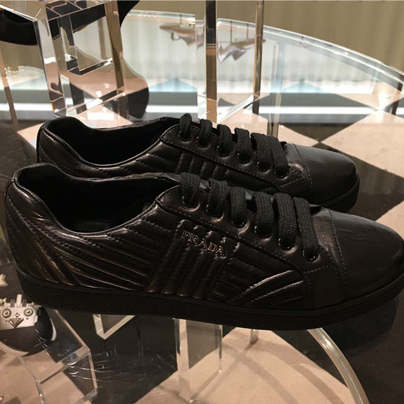 Close-up of black nappa leather and lace-up detail on Prada sneakers
