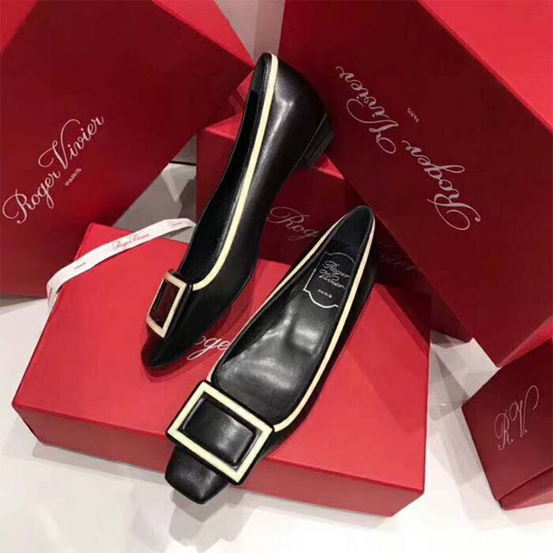 Close-up of black leather and graphic buckle on Roger Vivier ballerinas