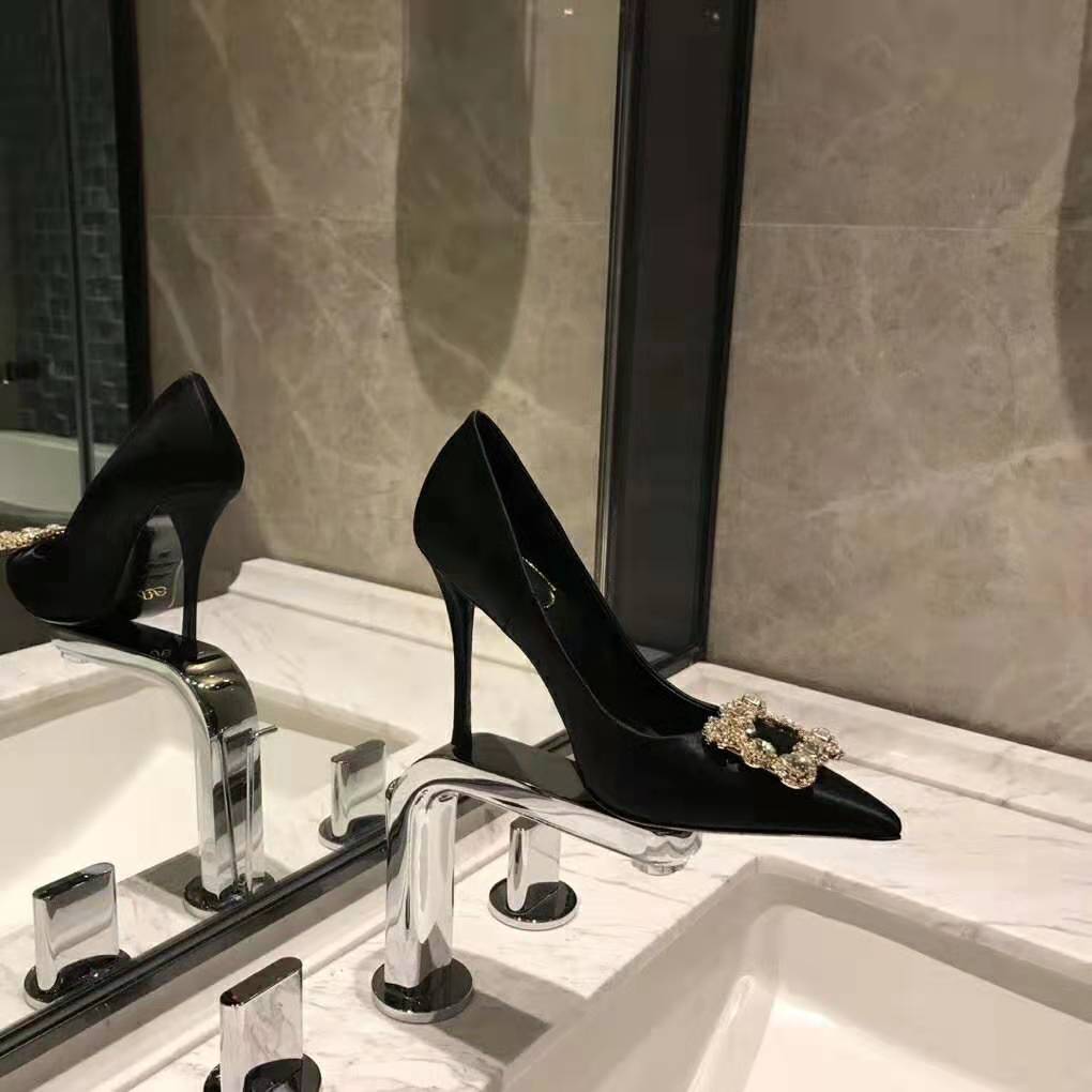 Close-up of sparkling flower strass buckle on Roger Vivier black pumps