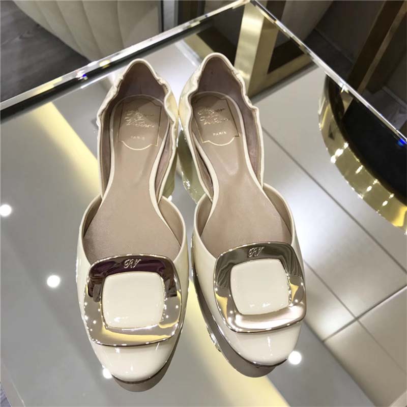 Close-up of signature buckle on Roger Vivier Chips Ballerinas white patent leather