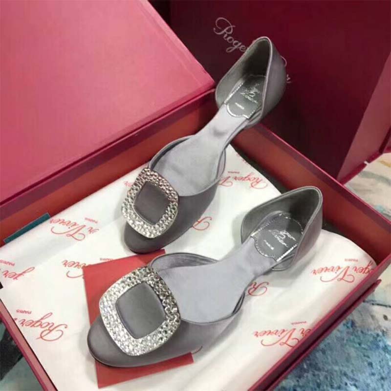 Close-up of silver leather and signature buckle on Roger Vivier ballerinas