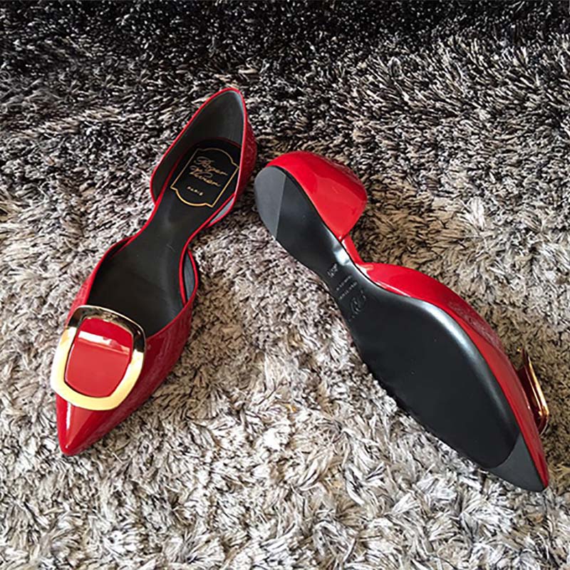 Close-up on signature buckle detail of Roger Vivier red patent ballerinas